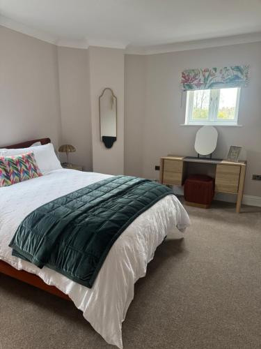 a bedroom with a large bed and a desk at Half Moon Nest - Refurbished throughout for 2026 in Diss