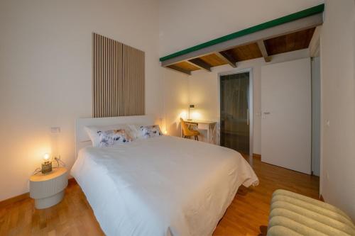 a bedroom with a large white bed and a chair at Urban Nest in Forlì
