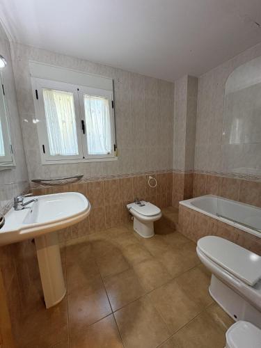 a bathroom with a sink and a toilet and a tub at Alpen1 Residencial Edison in Peniscola