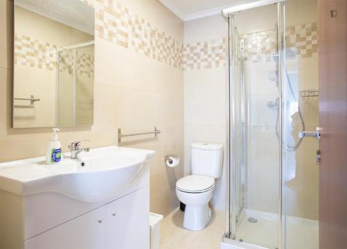 a bathroom with a sink and a toilet and a shower at Casa do Luiz in Lisbon