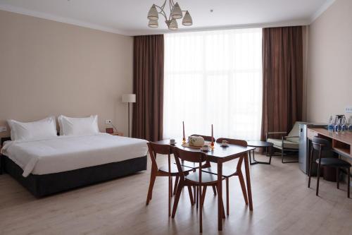 a hotel room with a bed and a table and a desk at Ton Azure Hotel in Tong