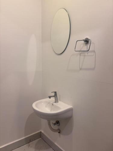 a white bathroom with a sink and a mirror at Mount Elbrus Home stay in Devikolam
