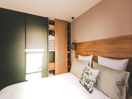 a bedroom with a bed with white pillows at Wadden lodge comfort in Westerland