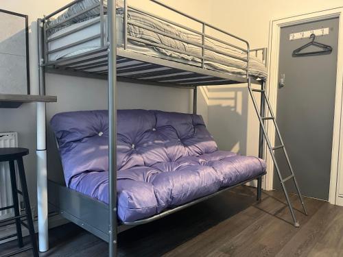 a bunk bed in a room with a purple mattress at Townsend lane accommodation in Liverpool