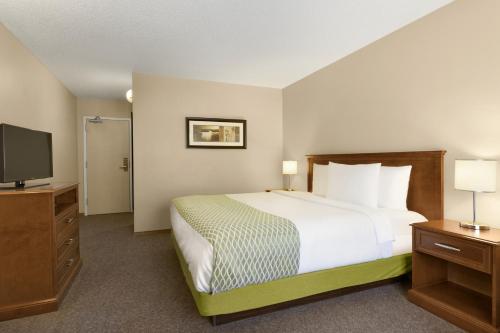 A bed or beds in a room at Colonial Square Inn & Suites