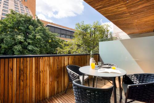 a patio with a table and chairs on a wooden deck at M217 Polanco by Zen Living in Mexico City