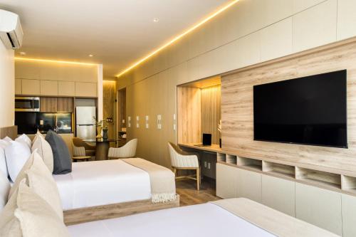 a hotel room with two beds and a flat screen tv at M217 Polanco by Zen Living in Mexico City