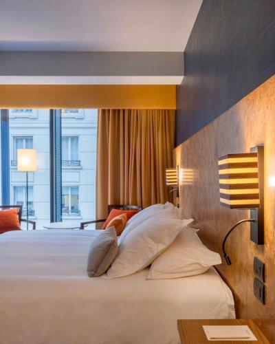 a bedroom with a large bed with a large window at Debaines Hotel Santiago in Santiago
