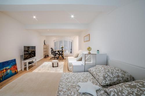 a white room with a bed and a table at Studio Américain Haut de Gamme in Toulon