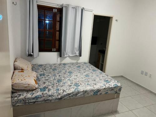 a small bed in a room with a window at Recanto do tdias in Mulungu