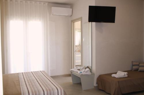a white room with a bed and a mirror at LA BELLA DIMORA in Otranto
