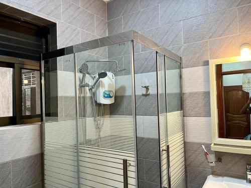 a shower in a bathroom with a glass shower stall at Quiet Home Apartment in Kigali