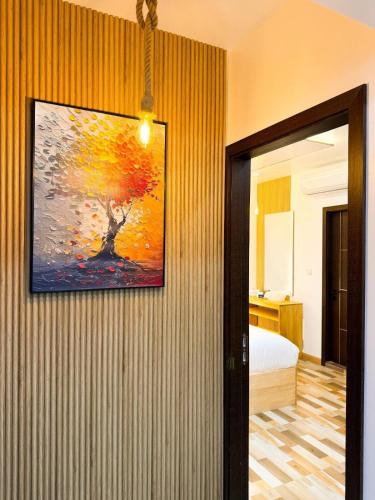 a room with a painting on a wall with a bed at Serenity Stay in Huraa