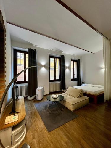 a bedroom with a bed and a couch and a table at Residenza Corrado in Mantova