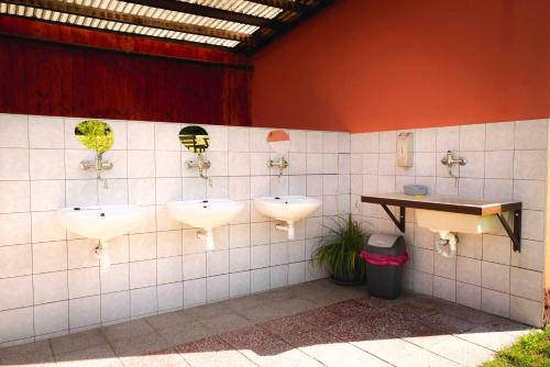 a public bathroom with three sinks and a counter at Kemp Selská rokle in Doksy