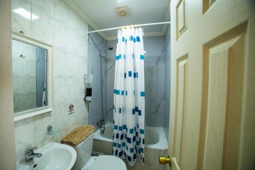 a bathroom with a sink and a shower curtain at Hotel Montecarlo in Caldera