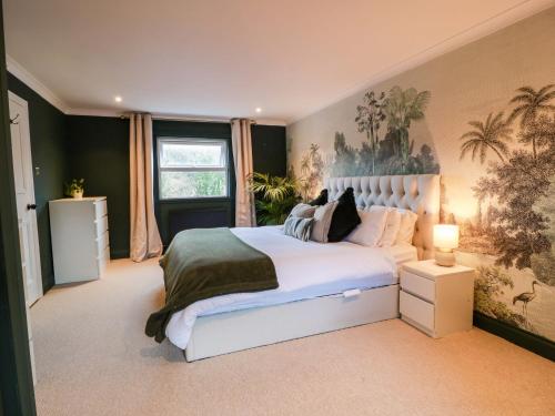 a bedroom with a large white bed with a painting on the wall at 7 Brewery Pool in Newton Stewart