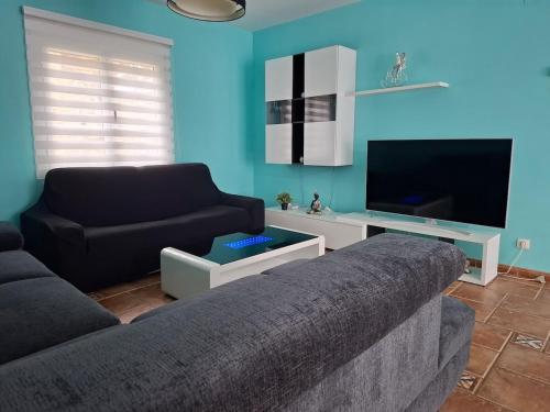 a living room with a couch and a flat screen tv at Casa familiar katandres in San Mamés de Meruelo