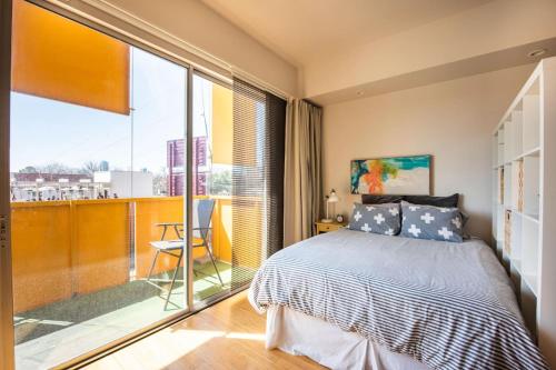 a bedroom with a bed and a large window at Studio nr Town Lake and E6th w Balcony by Austin Vacay in Austin