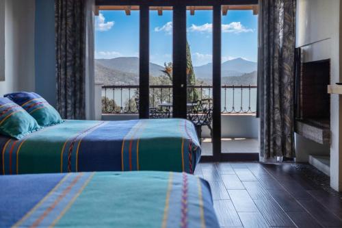 a bedroom with two beds and a balcony with a view at Villas Paraiso Valle de Bravo in Valle de Bravo