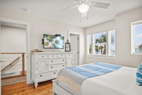 a bedroom with a bed and a dresser with a tv on it at La Concha Cottage in Port Aransas