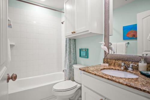 a bathroom with a sink and a toilet and a tub at La Concha Cottage in Port Aransas