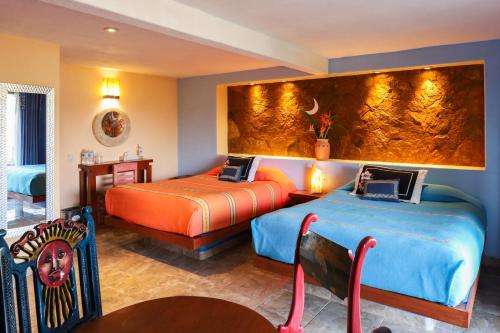 a hotel room with two beds and a wall at Villas Paraiso Valle de Bravo in Valle de Bravo