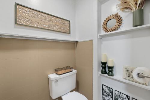 a bathroom with a toilet and a shelf with candles at A Cedar Key Dock Holiday! in Cedar Key
