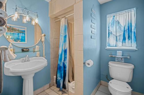 a blue bathroom with a sink and a toilet at Bluebird Day Inn & Suites in South Lake Tahoe