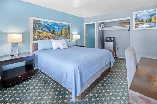 a hotel room with a large bed and a desk at Bluebird Day Inn & Suites in South Lake Tahoe