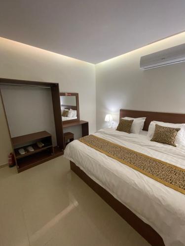 a bedroom with a large bed and a mirror at شقير للغرف الفندقية 1 in Medina