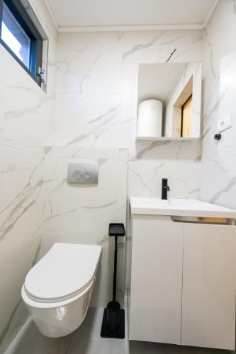a white bathroom with a toilet and a sink at Danube Retreat in Belgrade