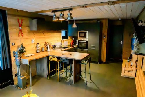 una cucina con un bancone e un'isola con sgabelli di Les Effalées a Thollon
