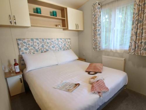 a bedroom with a bed with two items on it at 1. Forest Edge 2 Bedroom Statement Caravan in Saint Leonards