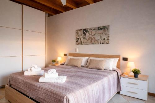 a bedroom with a bed with two towels on it at Ca Linda By Case al Lago in Desenzano del Garda