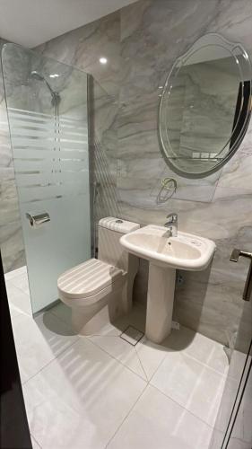 a bathroom with a toilet and a sink and a mirror at شقير للغرف الفندقية 1 in Medina