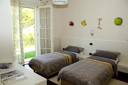 a bedroom with two beds and a table and a window at Villa Elisa Relax in Pozzolengo