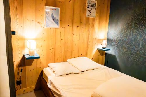 una piccola stanza con un letto e due lampade di Les Effalées a Thollon