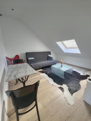 a living room with a couch and a table at Appart cosy mansardé Dijon gare 1km animaux acceptés in Dijon