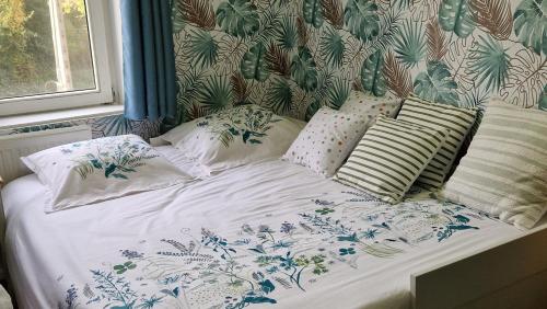 a bed with white sheets and pillows in a bedroom at Le Nichoir de la Biesme in Aiseau