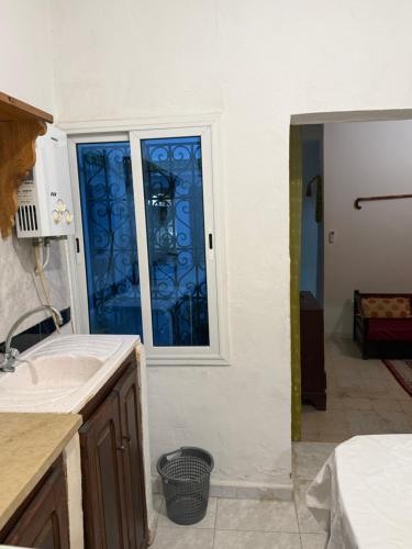 a kitchen with a window with blue glass at Dar kenza Tunis in Tunis