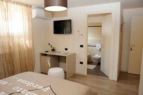 a room with a bed and a desk and a bathroom at Villa Elisa Relax in Pozzolengo