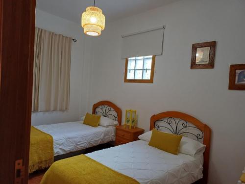 a room with two beds and a window at Vv - Casa Clary -Finca Medina in Alojera