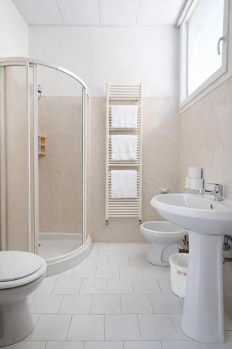 a bathroom with a toilet sink and a shower at Hotel Regina Fronte Mare in Rimini