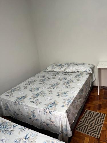 a bedroom with two beds and a table at suite privativa centro de Dourados in Dourados