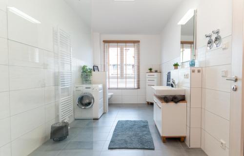 a white bathroom with a washing machine and a sink at 90 qm barrierefreies Apartment I Altstadt I Parkplatz in Quedlinburg