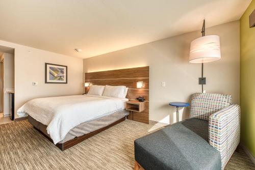 a hotel room with a bed and a chair at Holiday Inn Express & Suites - Manitou Springs by IHG in Manitou Springs
