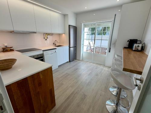 a kitchen with white cabinets and a counter top at Altura da Maré - Apartamento Duna in Altura