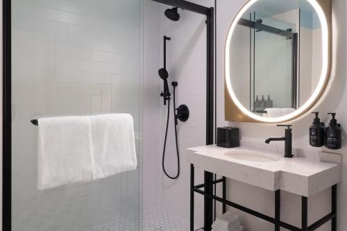 a white bathroom with a sink and a mirror at Hotel Indigo New Orleans - French Quarter by IHG in New Orleans