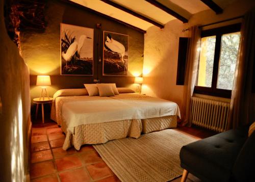 a bedroom with a bed and two pictures on the wall at Casa Rural La Cordonera in Herguijuela
